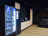 Lounge, jossa kylmäkaappi- jääkaappi sekä vedenotto piste